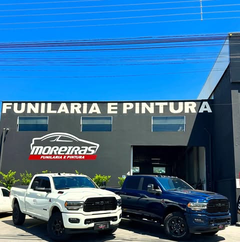Fachada da oficina Moreiras Funilaria e Pintura com caminhonetes RAM estacionadas